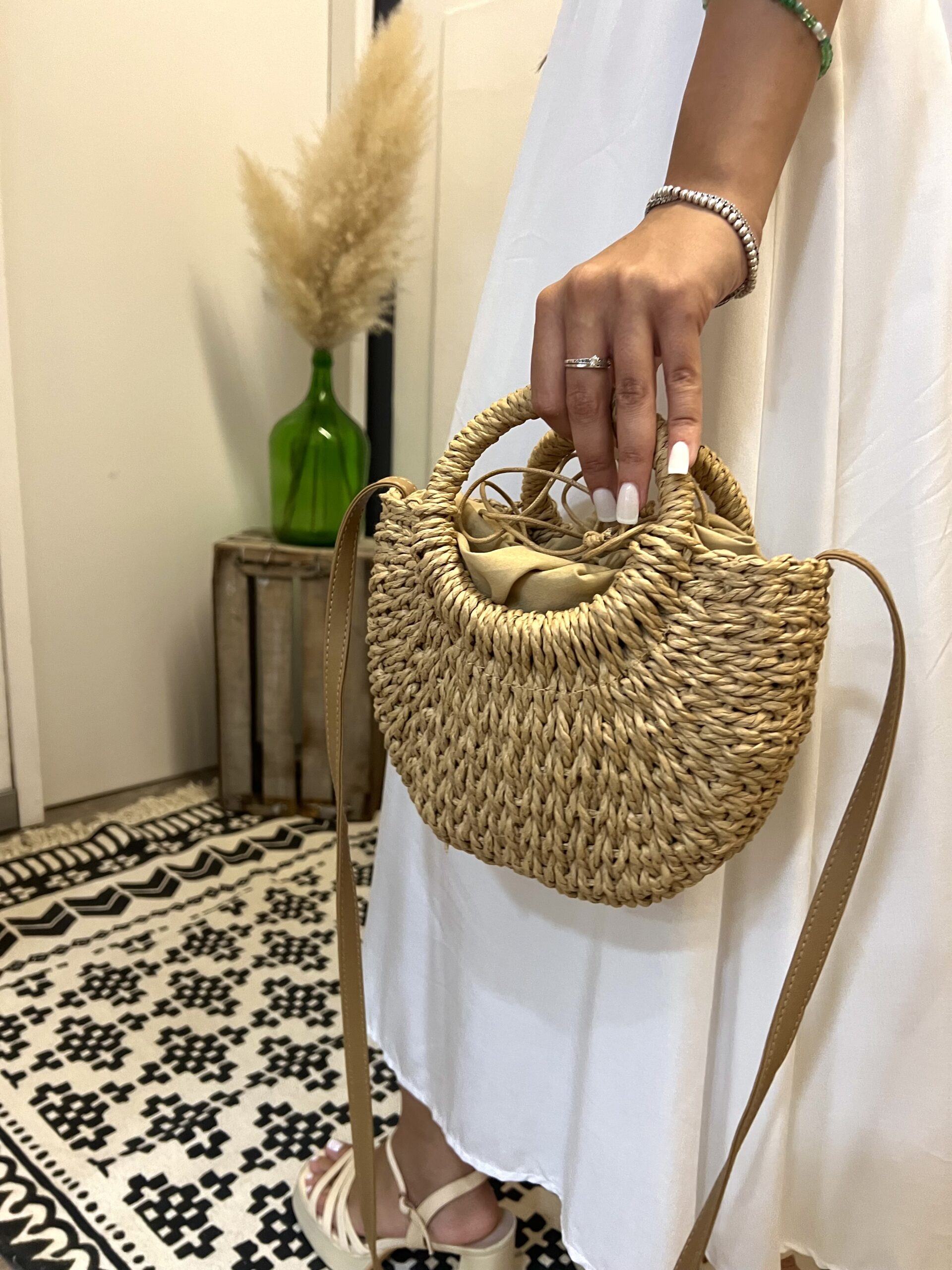 Pequena mala de palha com alça trançada, ideal para estilo casual de verão.